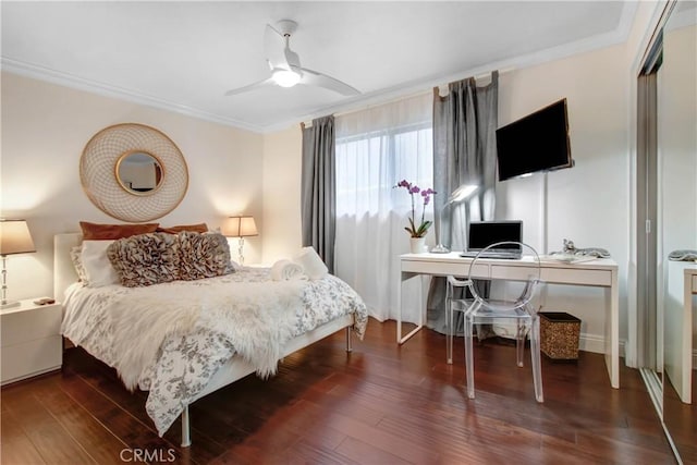 bedroom with wood finished floors, a ceiling fan, and crown molding