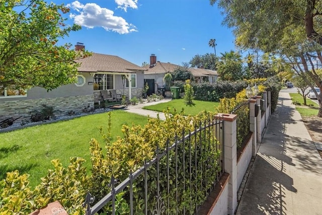 view of front of house with stone siding, a fenced front yard, and a front yard