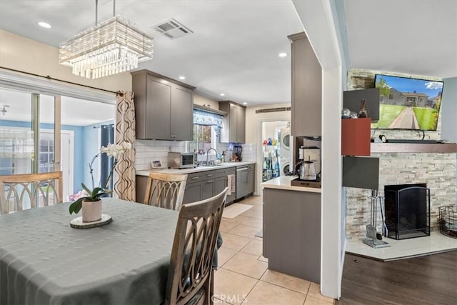 dining space featuring a toaster, recessed lighting, visible vents, a stone fireplace, and light tile patterned flooring