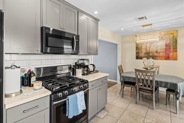 kitchen with visible vents, decorative backsplash, gray cabinets, stainless steel appliances, and light countertops