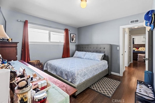 bedroom featuring baseboards, visible vents, and dark wood-type flooring