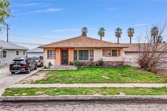 view of front of property with driveway, a front lawn, and stucco siding