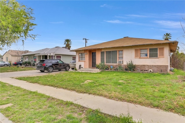 view of front facade with driveway, a front lawn, and stucco siding