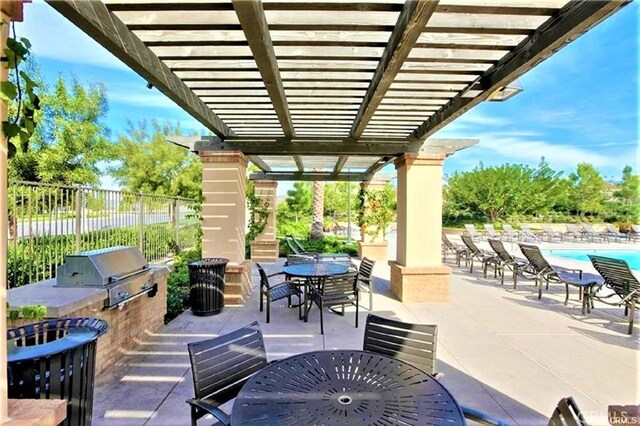 view of patio with outdoor dining space, fence, exterior kitchen, area for grilling, and a pergola