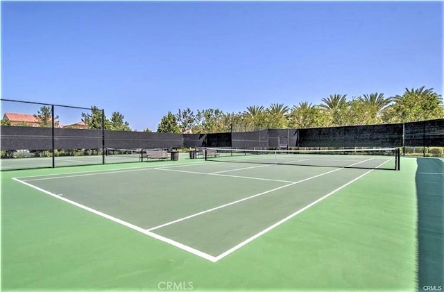 view of tennis court featuring fence