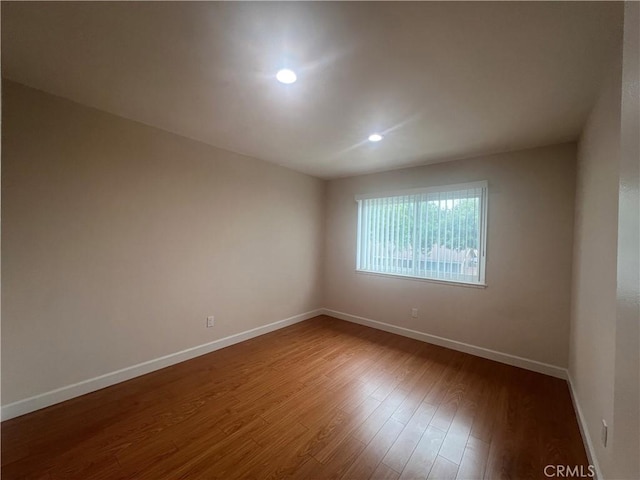 unfurnished room featuring recessed lighting, baseboards, and wood finished floors