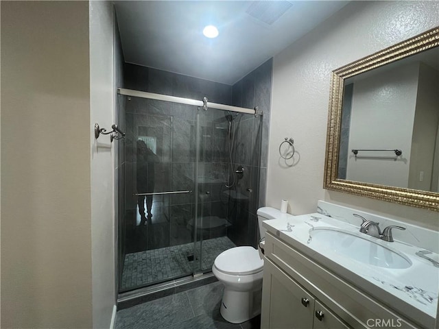 full bathroom featuring vanity, a shower stall, and toilet