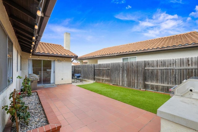 view of patio with a fenced backyard and a grill