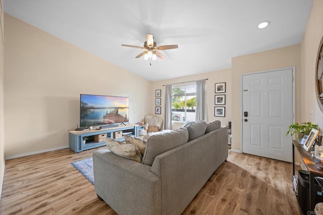 living area with vaulted ceiling, ceiling fan, wood finished floors, and baseboards