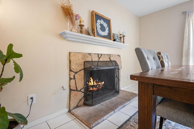 tiled home office with a lit fireplace and baseboards