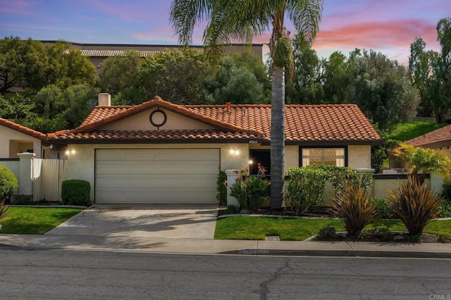 mediterranean / spanish-style house featuring a garage, concrete driveway, a chimney, a tiled roof, and stucco siding