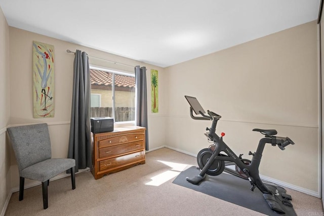 workout room with light carpet and baseboards