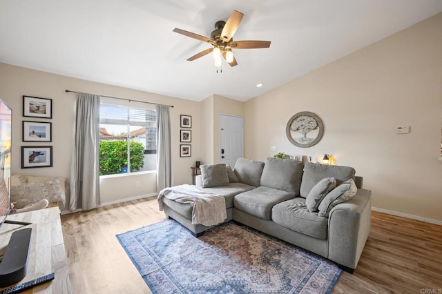 living room with lofted ceiling, a ceiling fan, baseboards, and wood finished floors