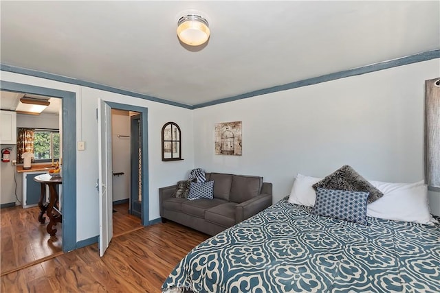 bedroom with baseboards and wood finished floors