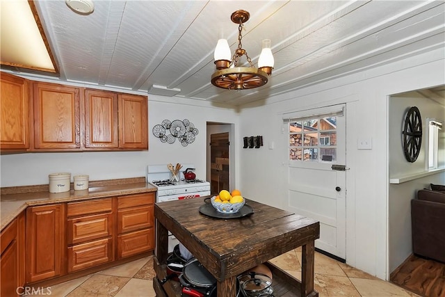 kitchen featuring a chandelier, hanging light fixtures, brown cabinetry, and light countertops