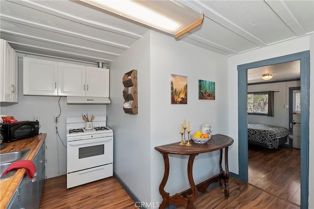 kitchen featuring black microwave, under cabinet range hood, white cabinetry, dark wood-style floors, and white gas range