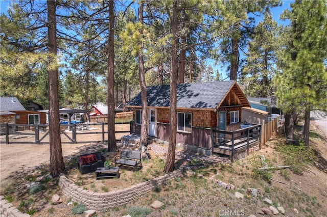 view of home's exterior with a shingled roof and fence