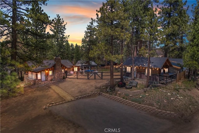 view of front of property featuring a deck, driveway, and a chimney