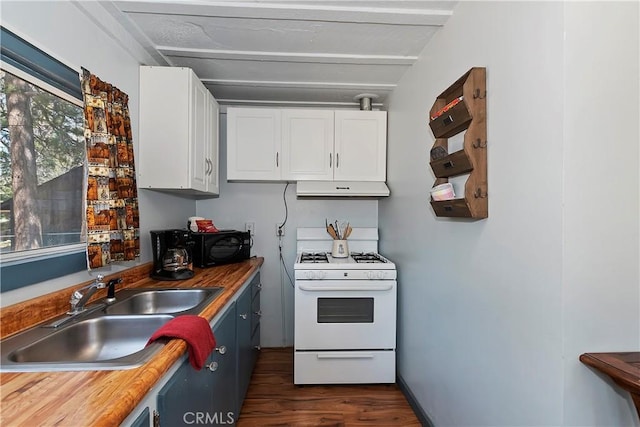 kitchen with butcher block countertops, white gas stove, under cabinet range hood, white cabinetry, and a sink