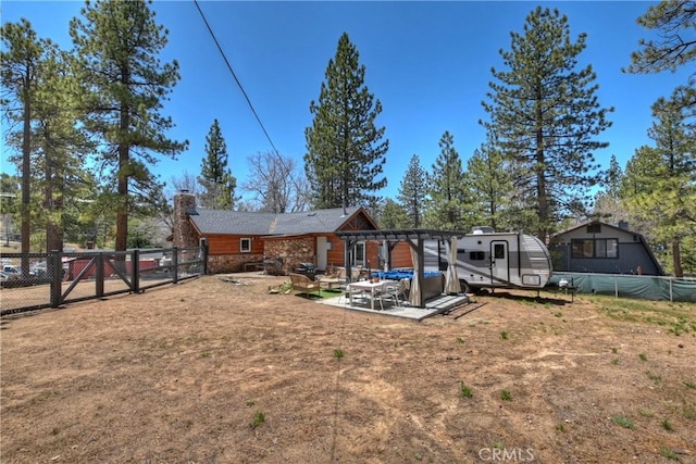 rear view of property featuring fence, a chimney, and a patio