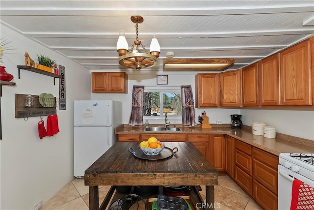 kitchen featuring a notable chandelier, white appliances, a sink, and brown cabinets