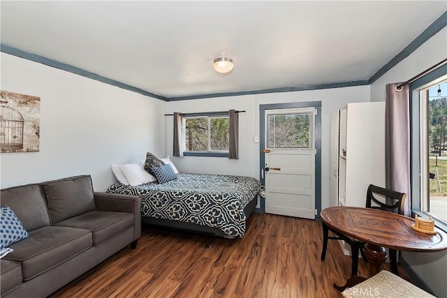 bedroom with dark wood-style floors and ornamental molding