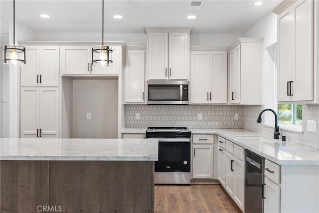 kitchen featuring visible vents, white cabinets, wood finished floors, stainless steel appliances, and a sink