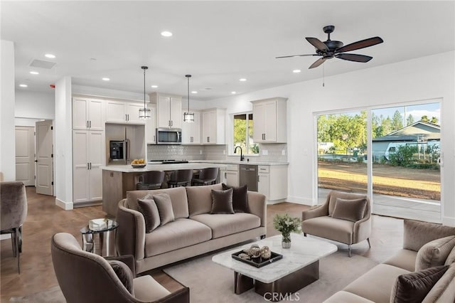 living room featuring a ceiling fan, recessed lighting, concrete flooring, and baseboards