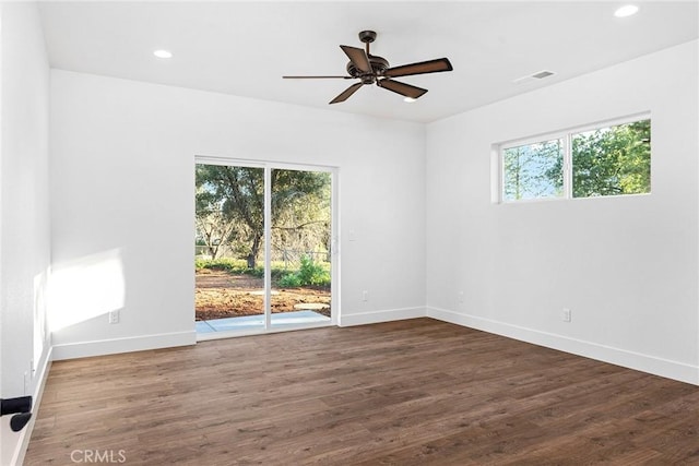 spare room with baseboards, recessed lighting, wood finished floors, and a healthy amount of sunlight