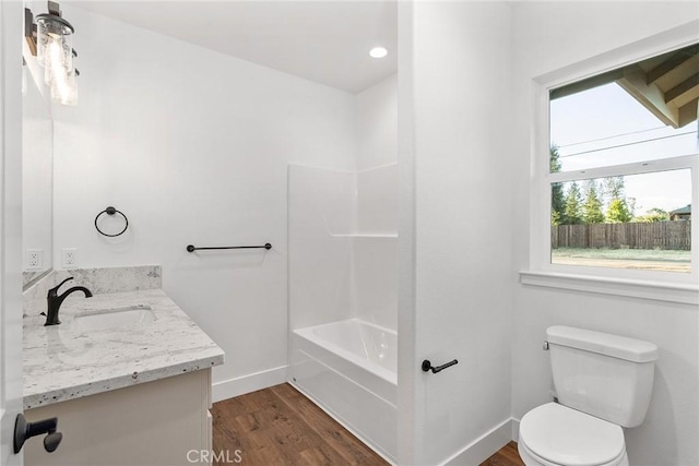 full bathroom with toilet, tub / shower combination, vanity, wood finished floors, and baseboards