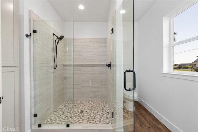 full bathroom with a stall shower, baseboards, wood finished floors, and recessed lighting