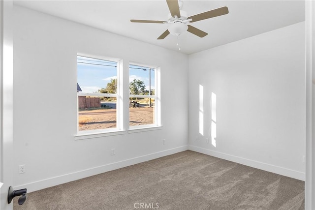 carpeted empty room with ceiling fan and baseboards