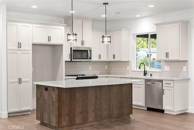 kitchen with a sink, white cabinetry, light wood-style floors, appliances with stainless steel finishes, and a center island