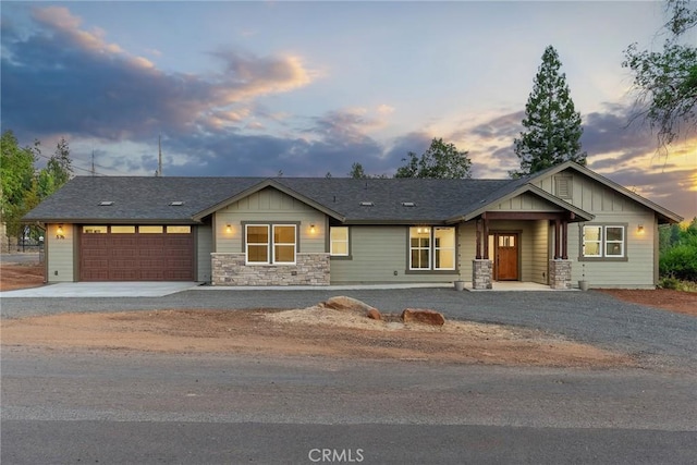 craftsman inspired home featuring driveway, stone siding, an attached garage, and board and batten siding