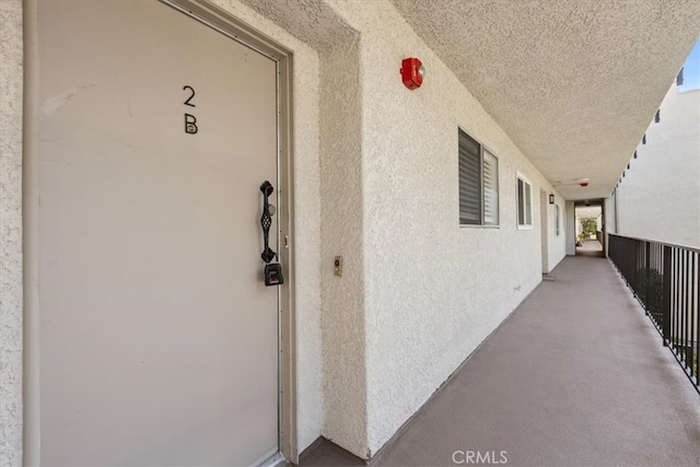 entrance to property featuring stucco siding and a balcony