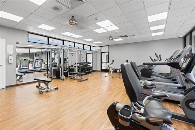 workout area featuring visible vents, a paneled ceiling, and wood finished floors