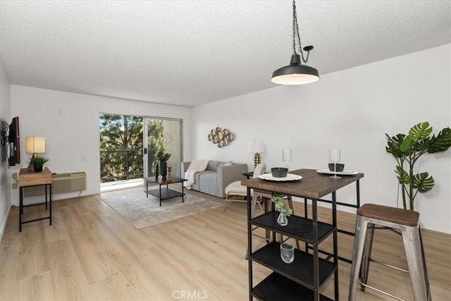 dining area featuring a textured ceiling and light wood-style flooring