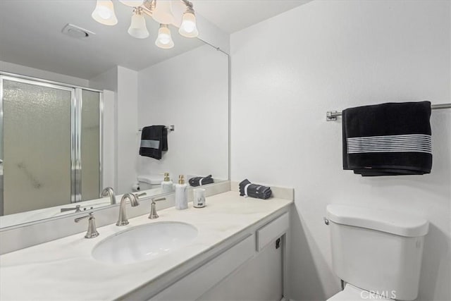 full bathroom with a shower stall, toilet, vanity, and an inviting chandelier