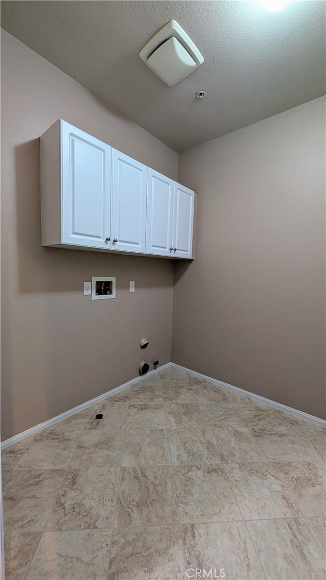 washroom with washer hookup, cabinet space, and baseboards