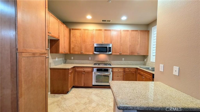 kitchen with a textured wall, recessed lighting, visible vents, light countertops, and appliances with stainless steel finishes