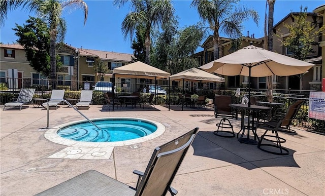 view of pool with a patio, fence, and a hot tub