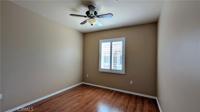 unfurnished room with ceiling fan, wood finished floors, and baseboards