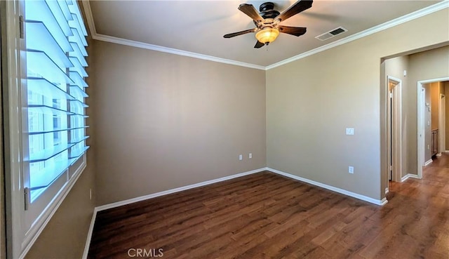 spare room featuring crown molding, baseboards, and wood finished floors