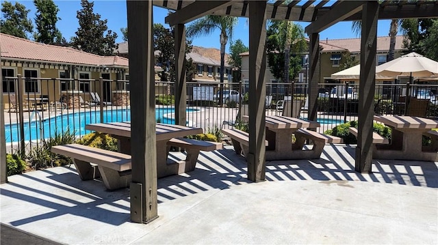 view of patio / terrace featuring a residential view, fence, a community pool, and a pergola