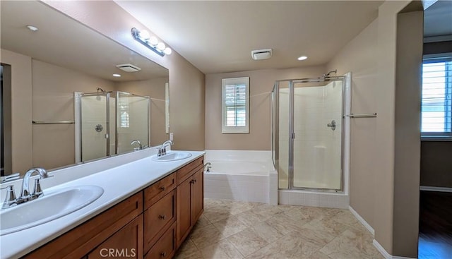 bathroom featuring a bath, a shower stall, and a sink