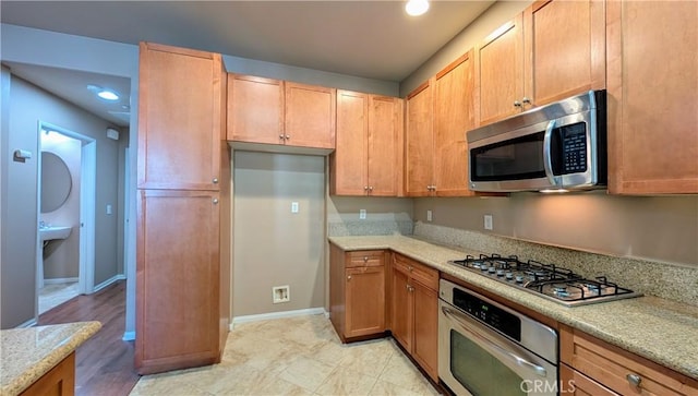 kitchen featuring baseboards and appliances with stainless steel finishes