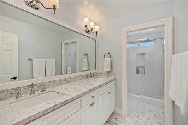 bathroom with double vanity, a shower stall, and a sink