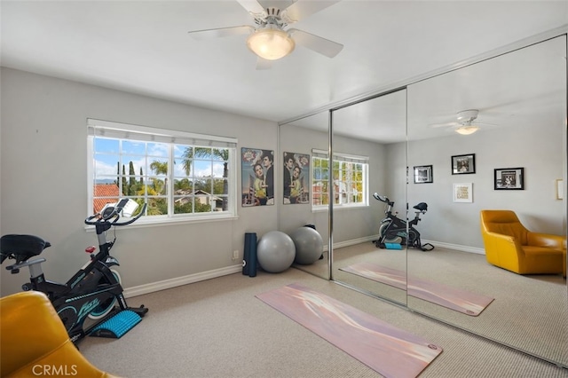 workout area featuring a ceiling fan, carpet, and baseboards