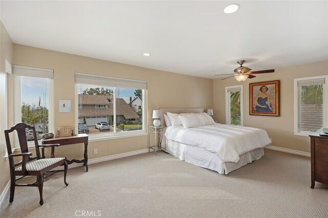 bedroom with light colored carpet, recessed lighting, baseboards, and ceiling fan