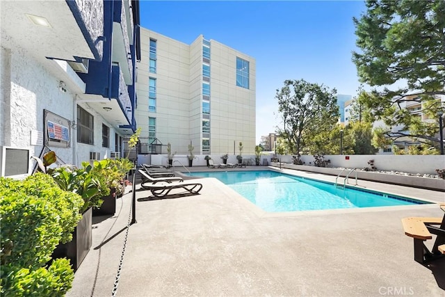 pool with a patio area and fence